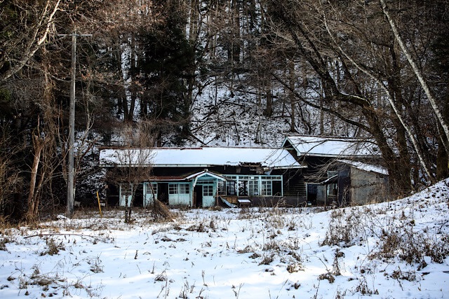 2026年1月2日に撮影した、長野県の廃村にある贄川小学校桑崎冬季分校の木造校舎。積雪した平地に建つ古い平屋建ての校舎は、屋根の一部が崩落し、窓枠が歪むなど老朽化が著しい。