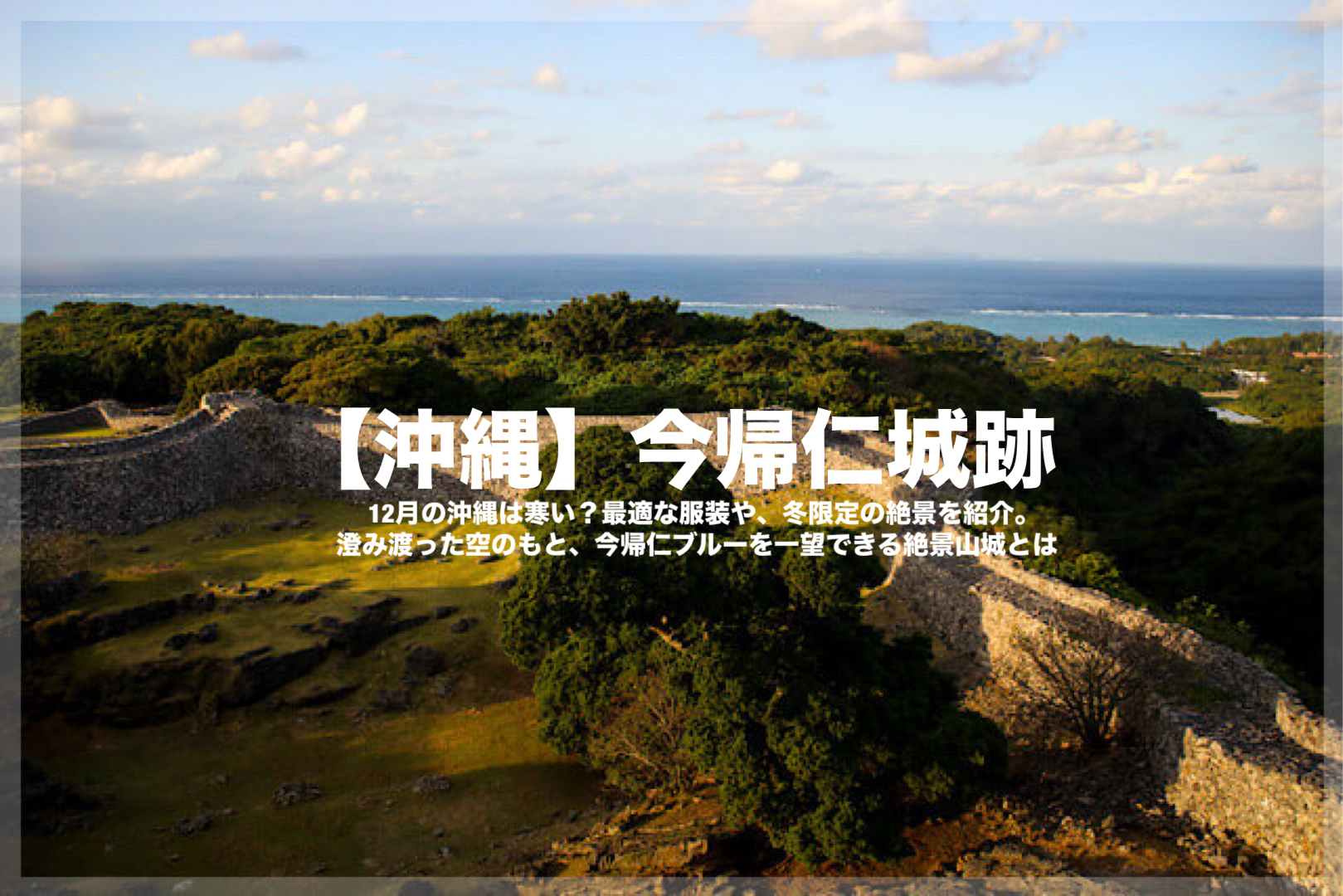 沖縄の世界遺産、今帰仁城跡の全景。石垣が巡る城郭と、冬の澄み渡った青空の下に広がる東シナ海の絶景。記事タイトル「12月の今帰仁城観光ってどうなの？寒い？服装の注意点や最新の混雑状況を解説。桜がなくても大満足だった、あふれる魅力を現地レポ！」のアイキャッチ画像。