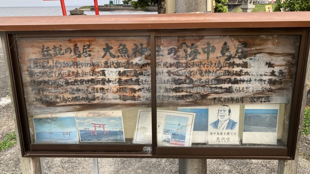 大魚神社の由来が記された現地の案内板。約300年前の悪代官の伝説が詳しく書かれており、中央にはコミカルな悪代官のイラストも添えられている。
