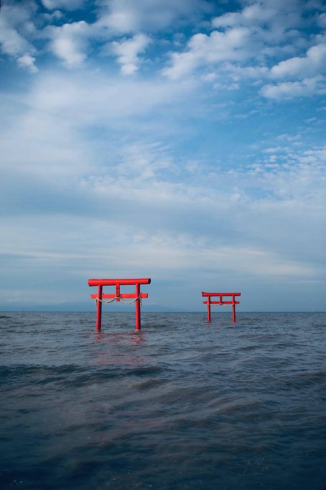 青空と白い雲の下、満潮の有明海に並ぶ大魚神社の海中鳥居。手前の鳥居と奥の鳥居が重なり、海へと続く奥行きを感じさせる構図。