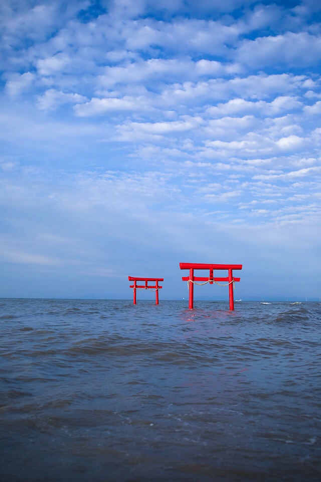 青空のもと、満潮に近い水位の有明海に浮かぶ大魚神社の赤い海中鳥居。