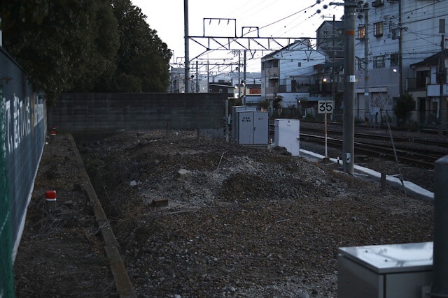 現役の阪和線の線路脇に残されている、線路が撤去されて土砂が盛られた状態の阪和貨物線・安全側線の跡地