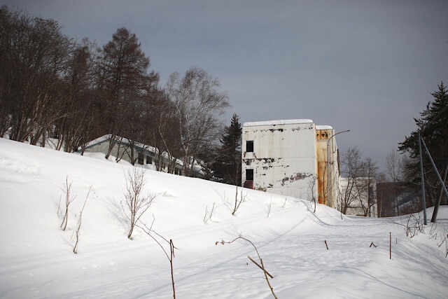 深い雪に包まれた夕張の山間に佇む、ファミリースクールふれあい（旧夕張第二小学校・旭小学校）の校舎外観。