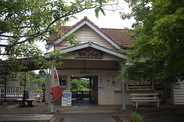 養老渓谷駅の木造駅舎正面。「養老溪谷驛」の木彫り看板と緑に囲まれた玄関口。
